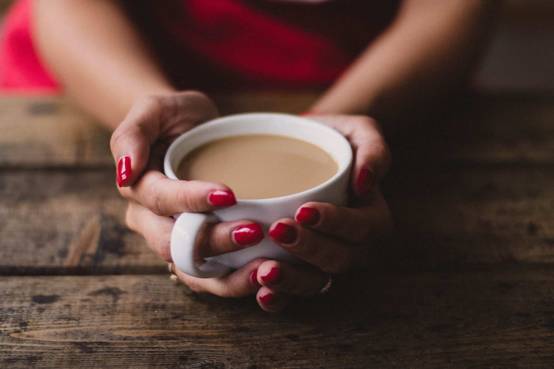 women holding cup of coffee