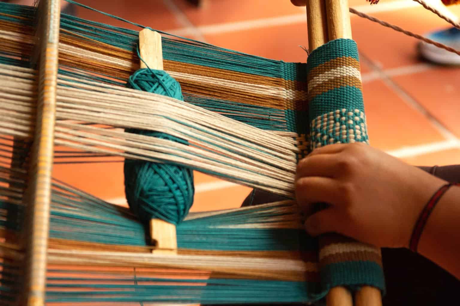 pexels-photo-14330289 | goodthoughtsgoodlives a person using a loom