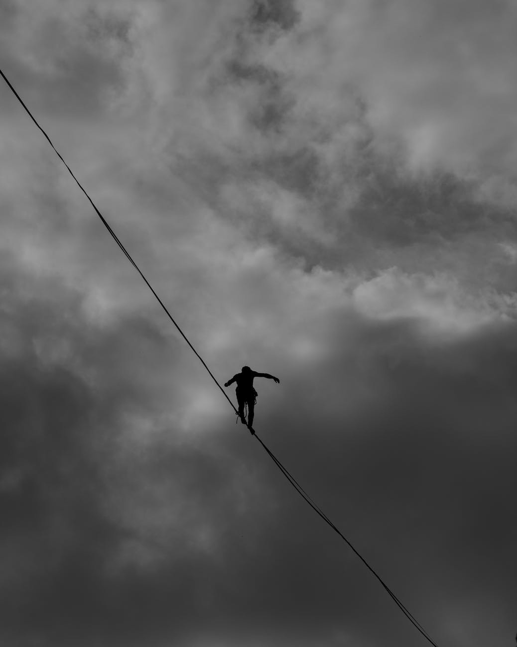 pexels-photo-2225771 | goodthoughtsgoodlives low angle photo grayscale of person tightrope walking