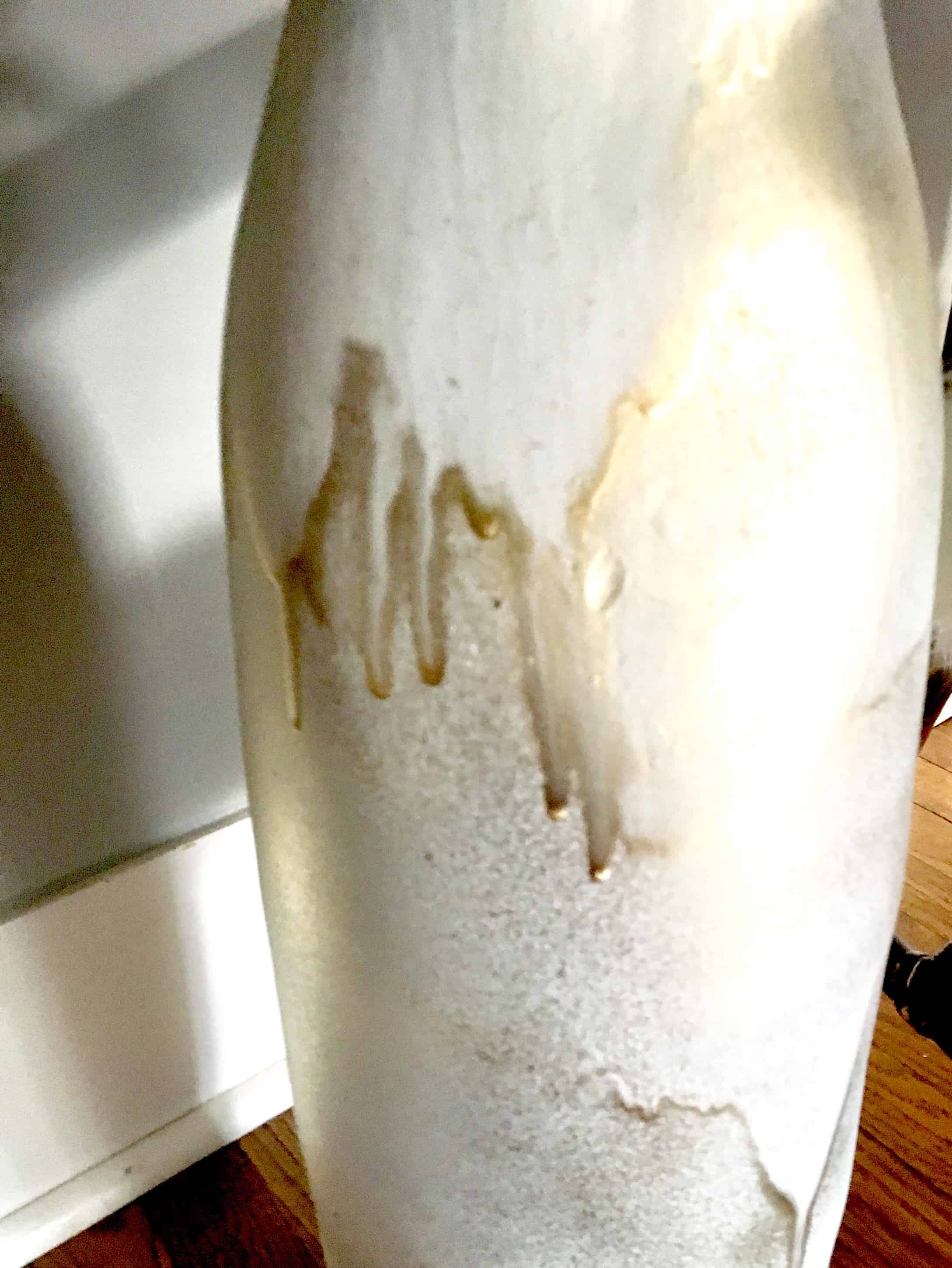 large white vase, about three feet high, painted white the painted over in spots with gold.,