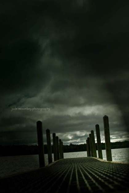 a dock on the water on a dark and storm day. Very gloomy