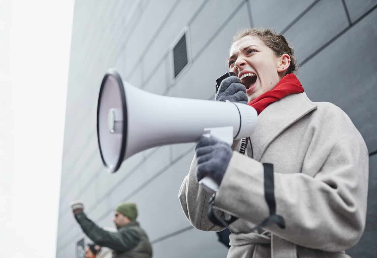 a woman in gray coat holding white megaphone/depression
