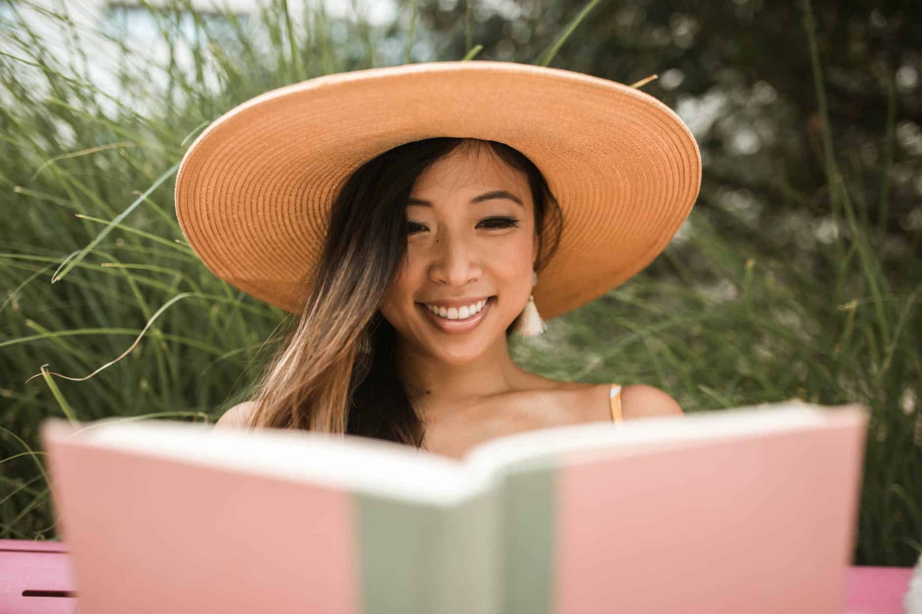 A blog post for you from someone else | goodthoughtsgoodlives smiling woman wearing a sun hat and reading a book
