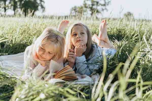 little girls lying on green grass field/depression is totally manageable