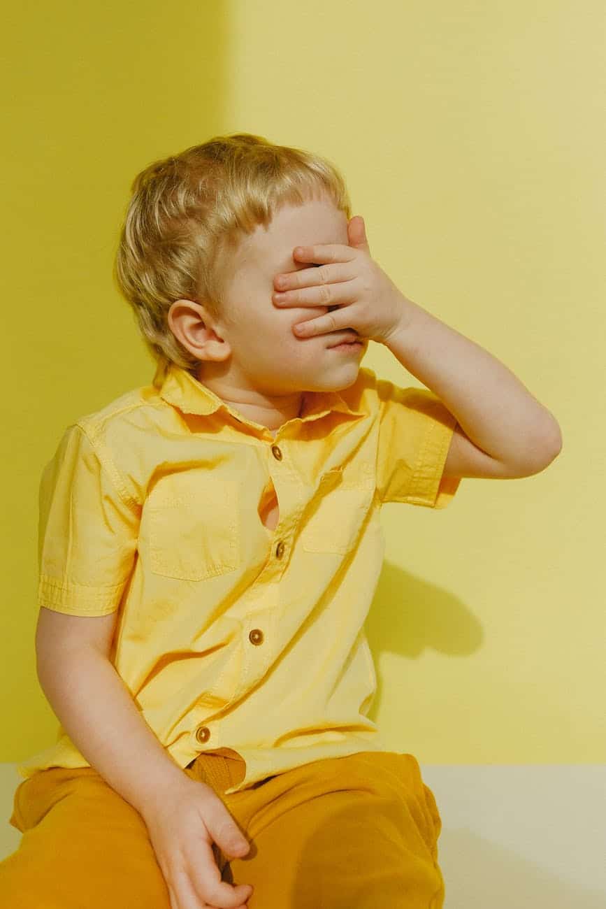 photo of a boy covering his eyes/hiding