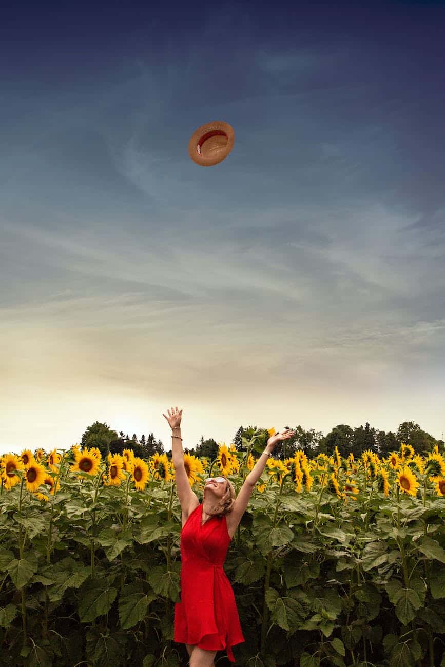 photo of woman throwing her straw hat upwards in a happy way/God always has our backs.