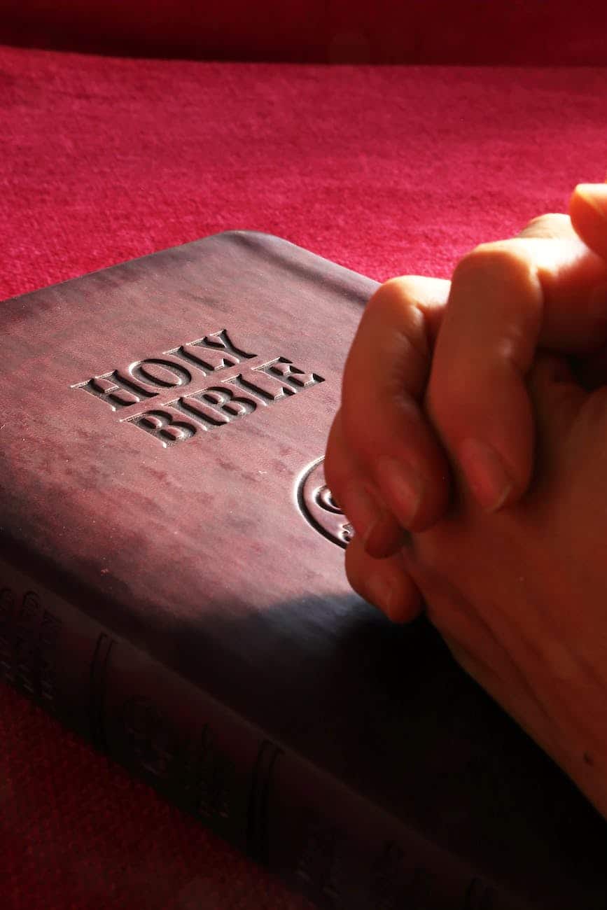 bible with folded hands/prayer