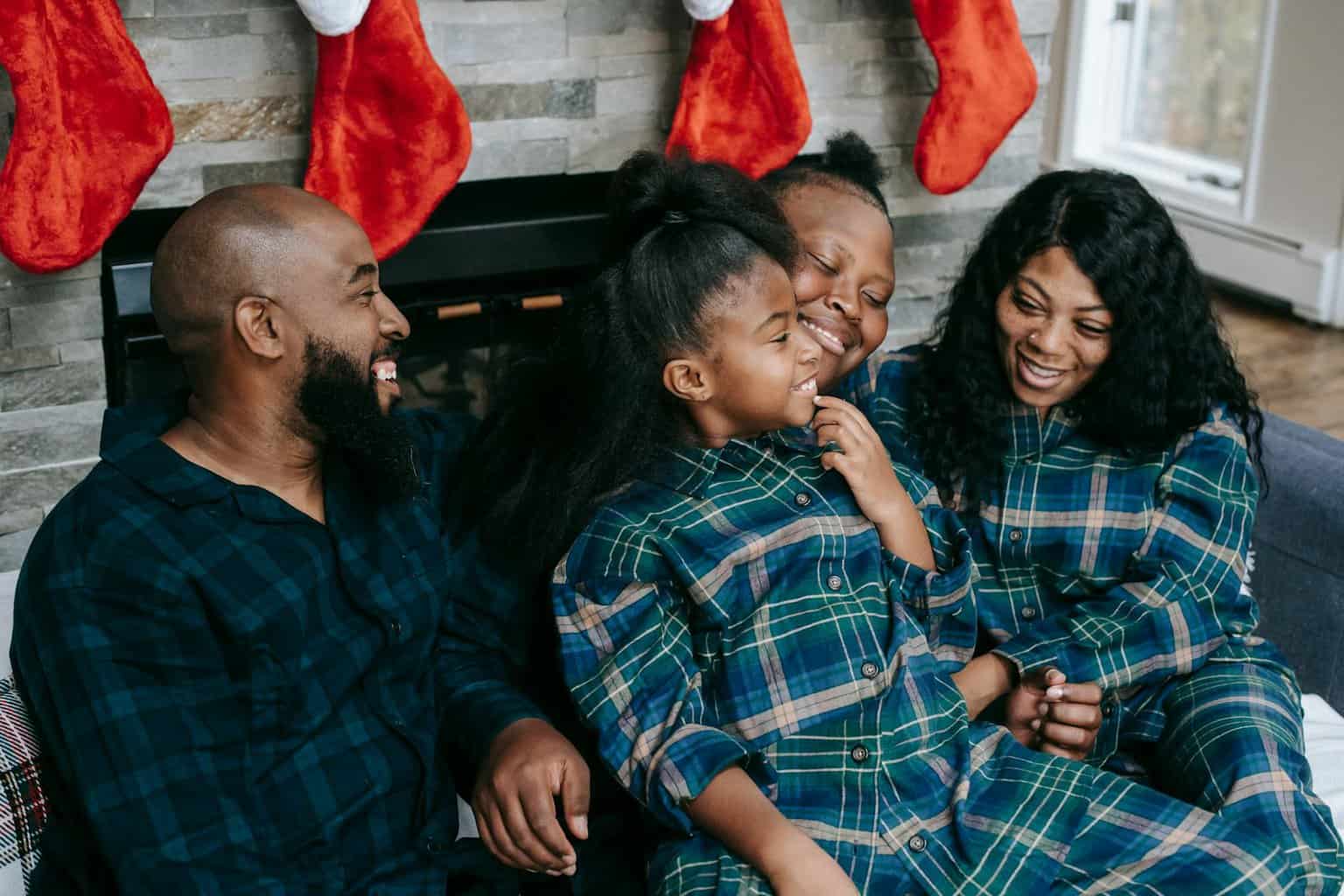 joyful black family cuddling together on sofa/Christimas wishes