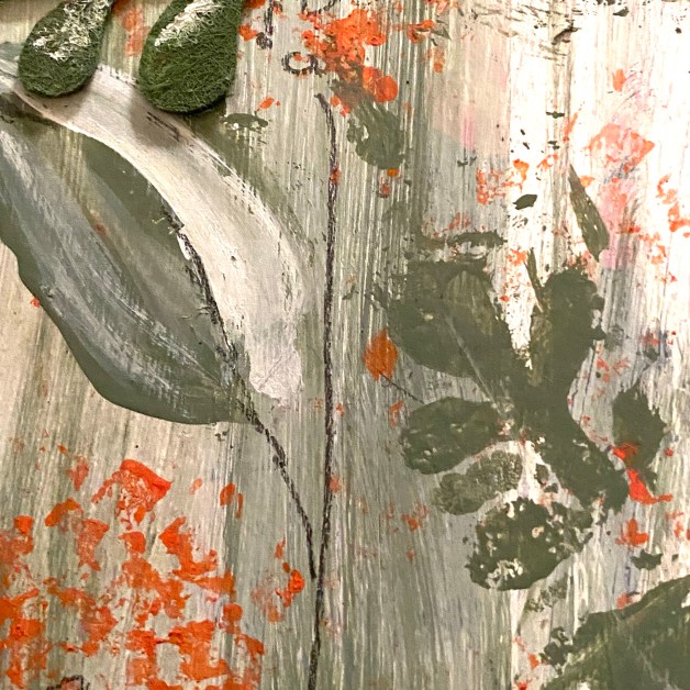 A close-up of a textured, abstract painting with broad brushstrokes in shades of gray, green, and splatters of orange on a wooden surface.