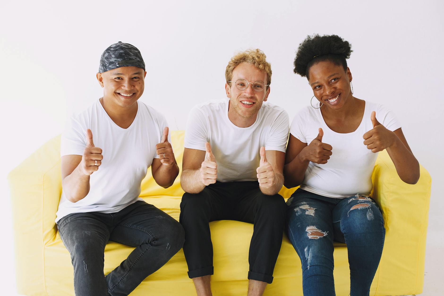 smiling people sitting on couch showing thumbs up/free