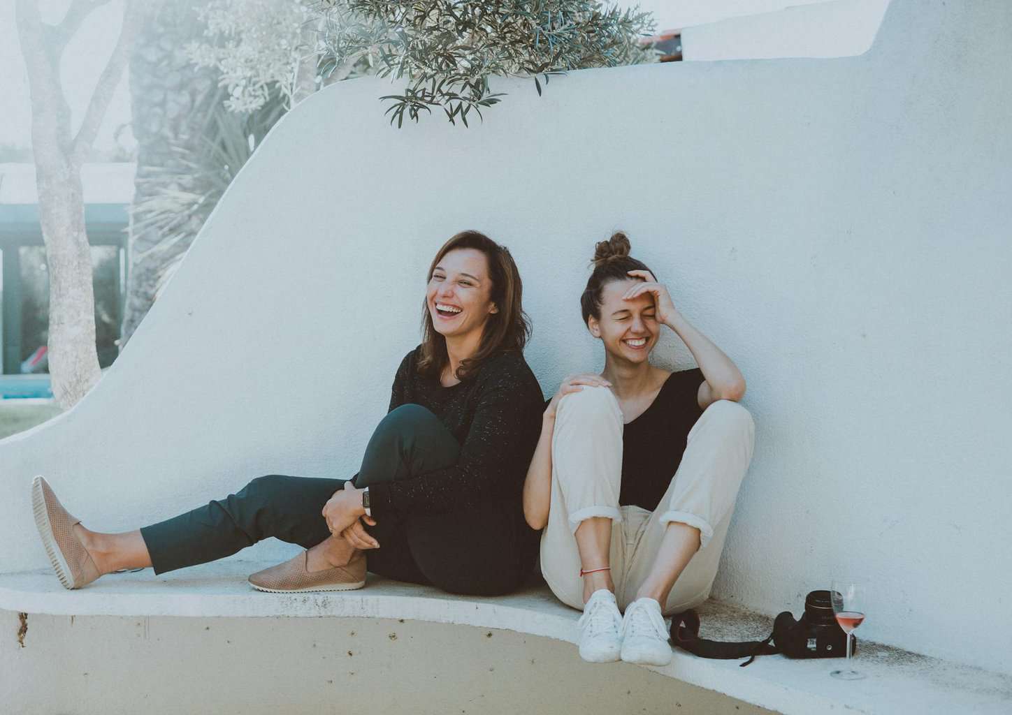 two women sitting on white bench/friendship