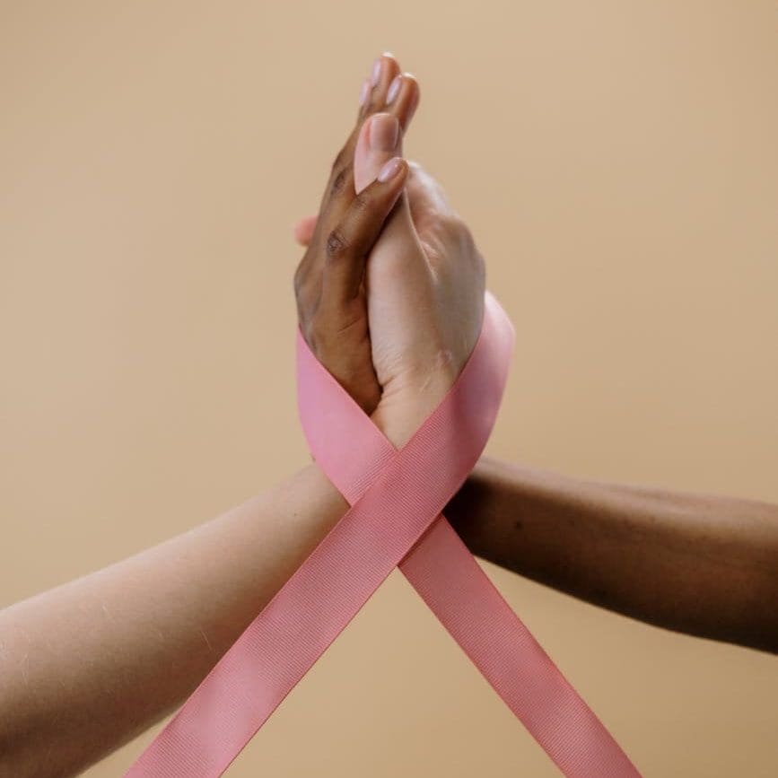 two people holding their hands with pink ribbon/relationships/commitment
