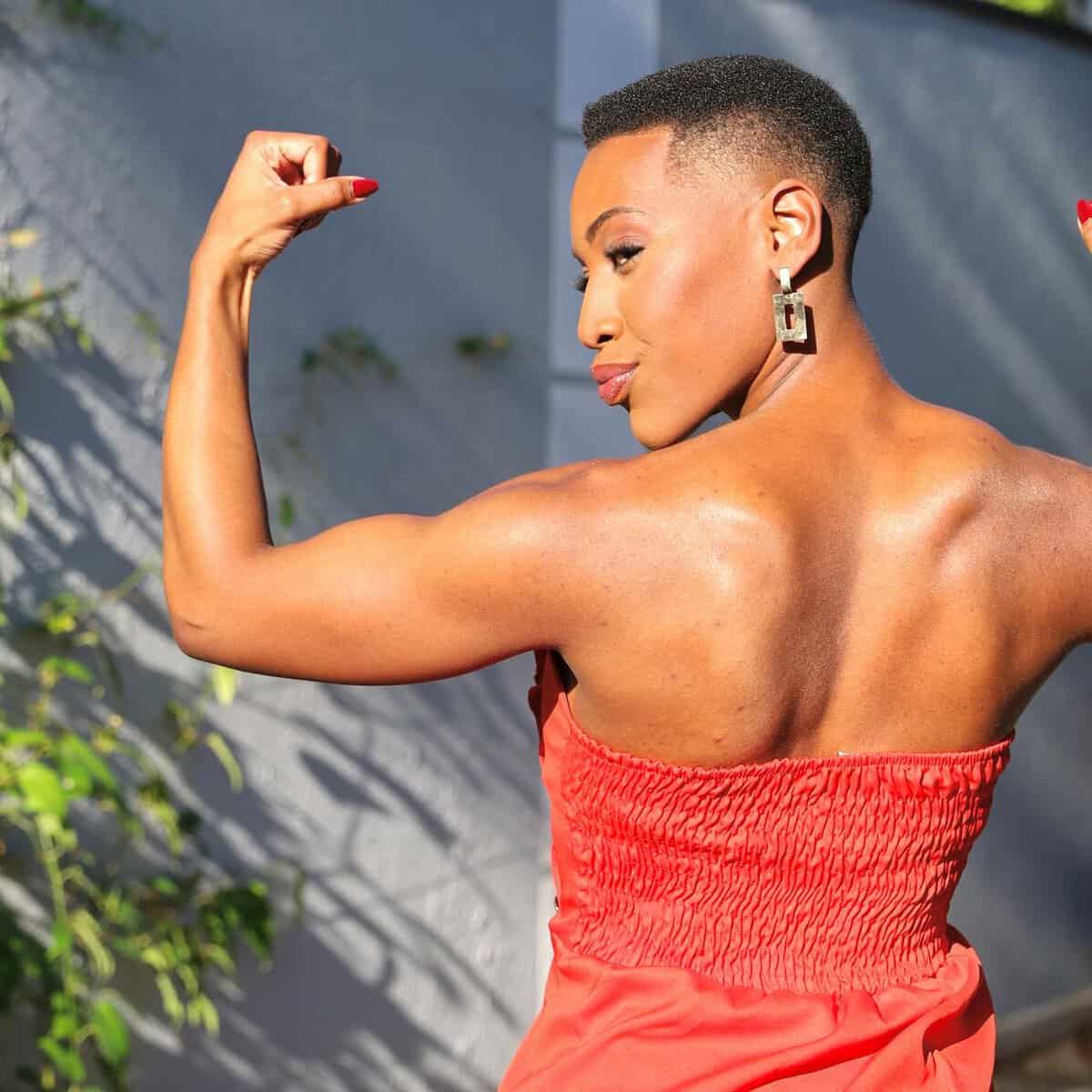 confident woman flexing muscles in sunlight/depression