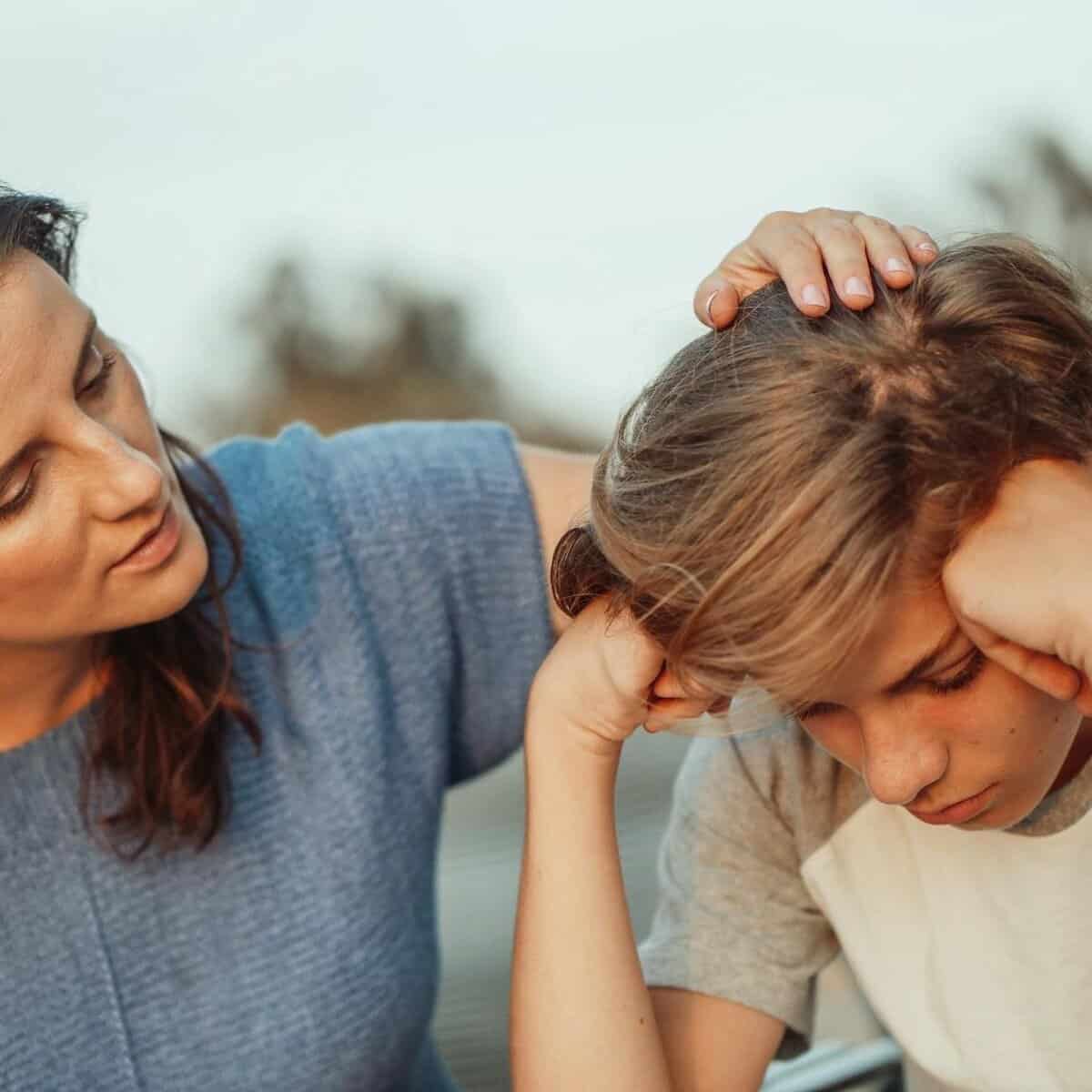 woman in blue shirt talking to a young man in white shirt
