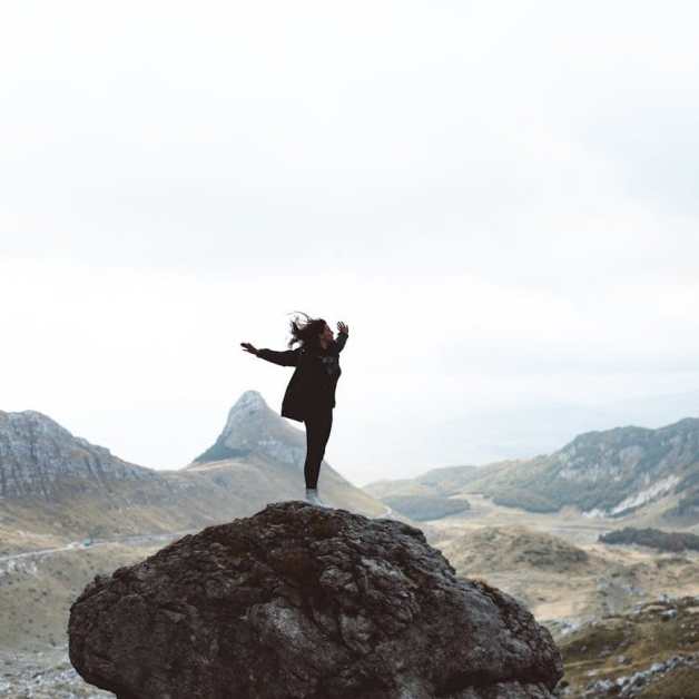 woman standing on a boulder