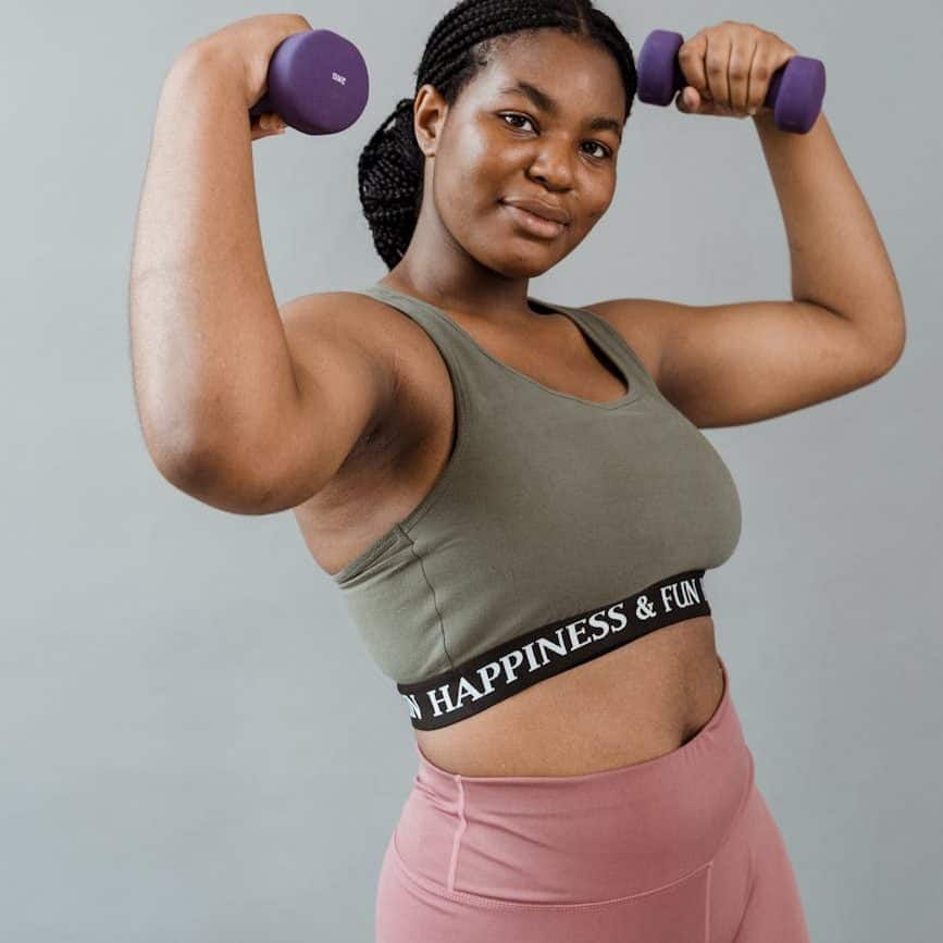 a woman in active wear lifting dumbbells