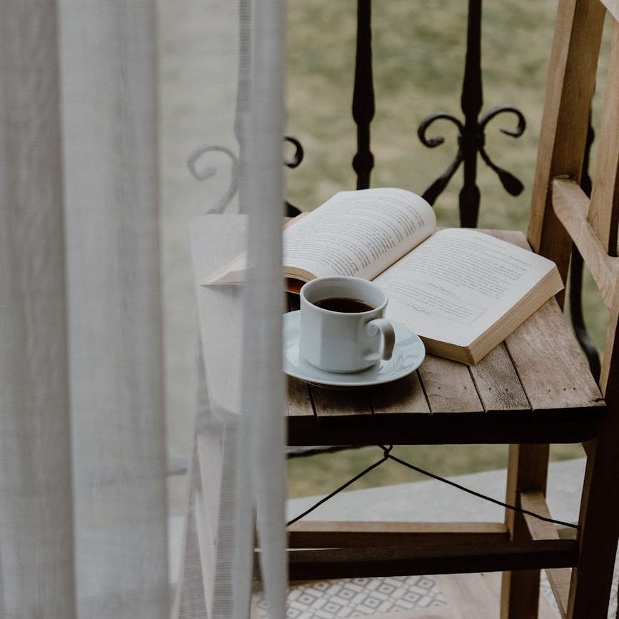 chair with book and cup of coffee on balcony