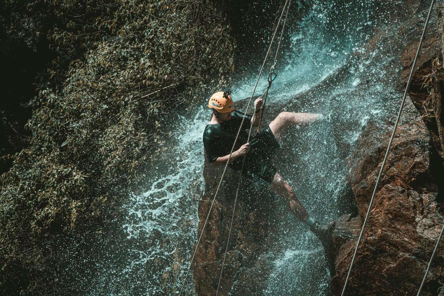 active man rappelling on cliff/depreession