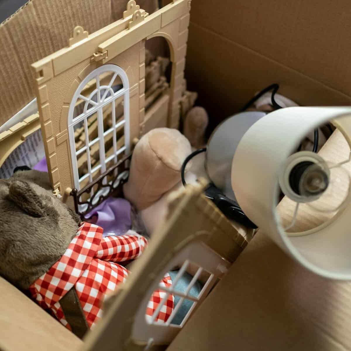 a cardboard box filled with toys and a lamp shade//Stop waiting. Live your life.