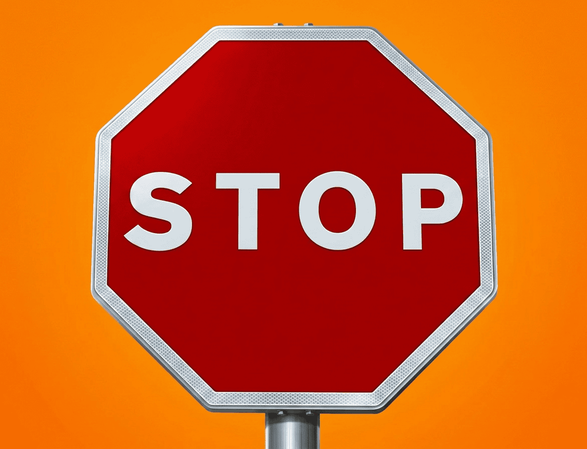 red stop sign against cloudy sky