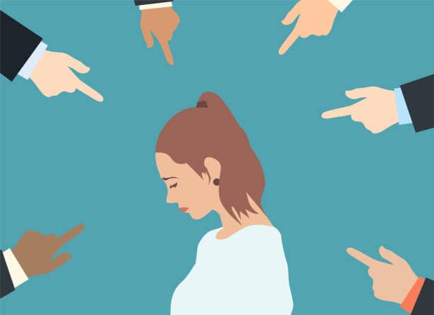 istockphoto-1029472394-612x612 | goodthoughtsgoodlives Woman with a downcast gaze as several hands point at her from all directions.