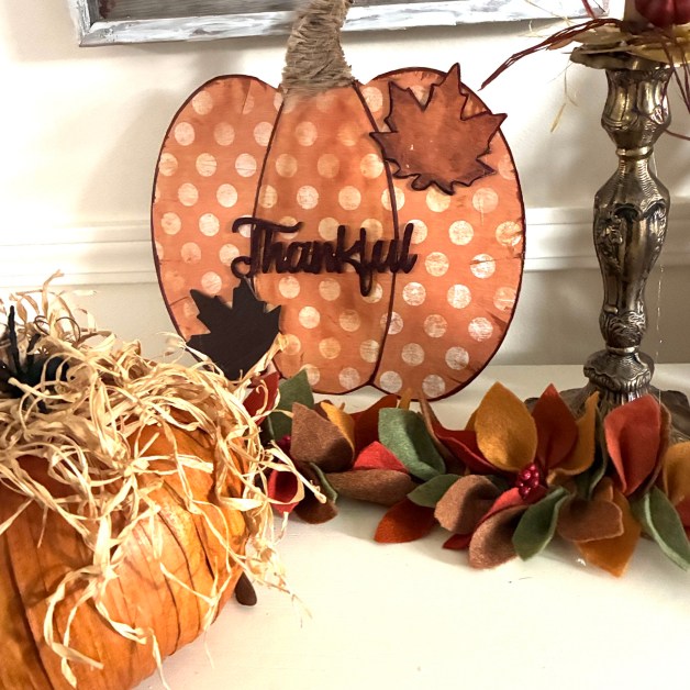 img_5916 | goodthoughtsgoodlives Polka-dotted orange pumpkin cutout with a brown maple leaf accent, surrounded by fall decor and straw accents.