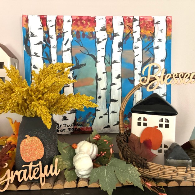 img_6031-1 | goodthoughtsgoodlives Autumn-themed display featuring a birch-tree painting, faux pumpkins and gourds, and dried yellow flowers in a wicker basket.